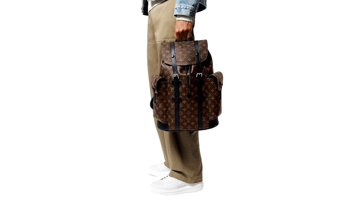 Man holding Louis Vuitton monogram backpack.