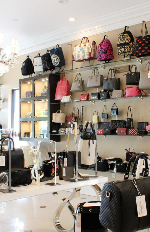 Display of luxury designer handbags and wallets in Queen Bee of Beverly Hills store setting