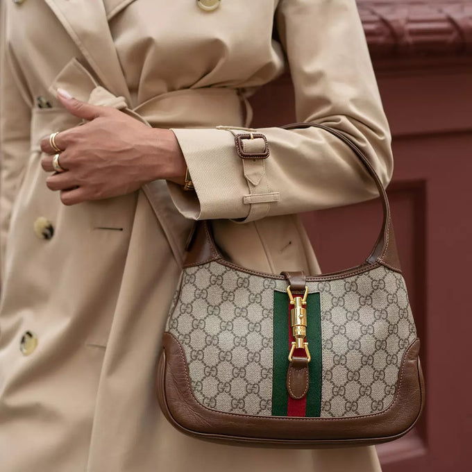 Detail shot of woman carrying gucci bag with gold hardware