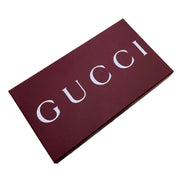 Gucci-branded burgundy box with large white GUCCI lettering, photographed on a plain white background.