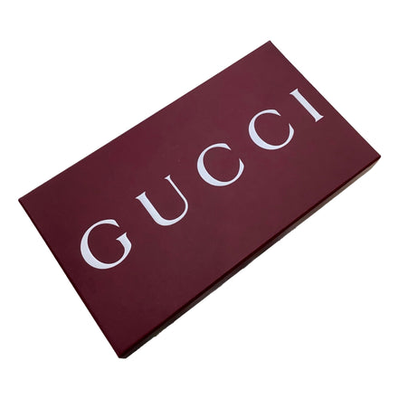 Gucci-branded burgundy box with large white GUCCI lettering, photographed on a plain white background.