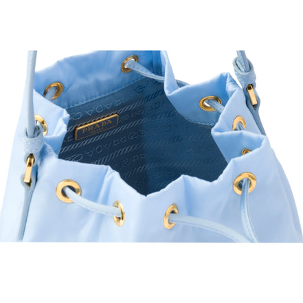 Prada duet orstrich leather and nylon bucket bag in blue available at Queen Bee of Beverly Hills