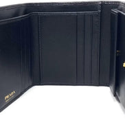 Prada Vitello Move Trifold Compact Wallet Black Leather Triangle Plaque available at Queen Bee of Beverly Hills