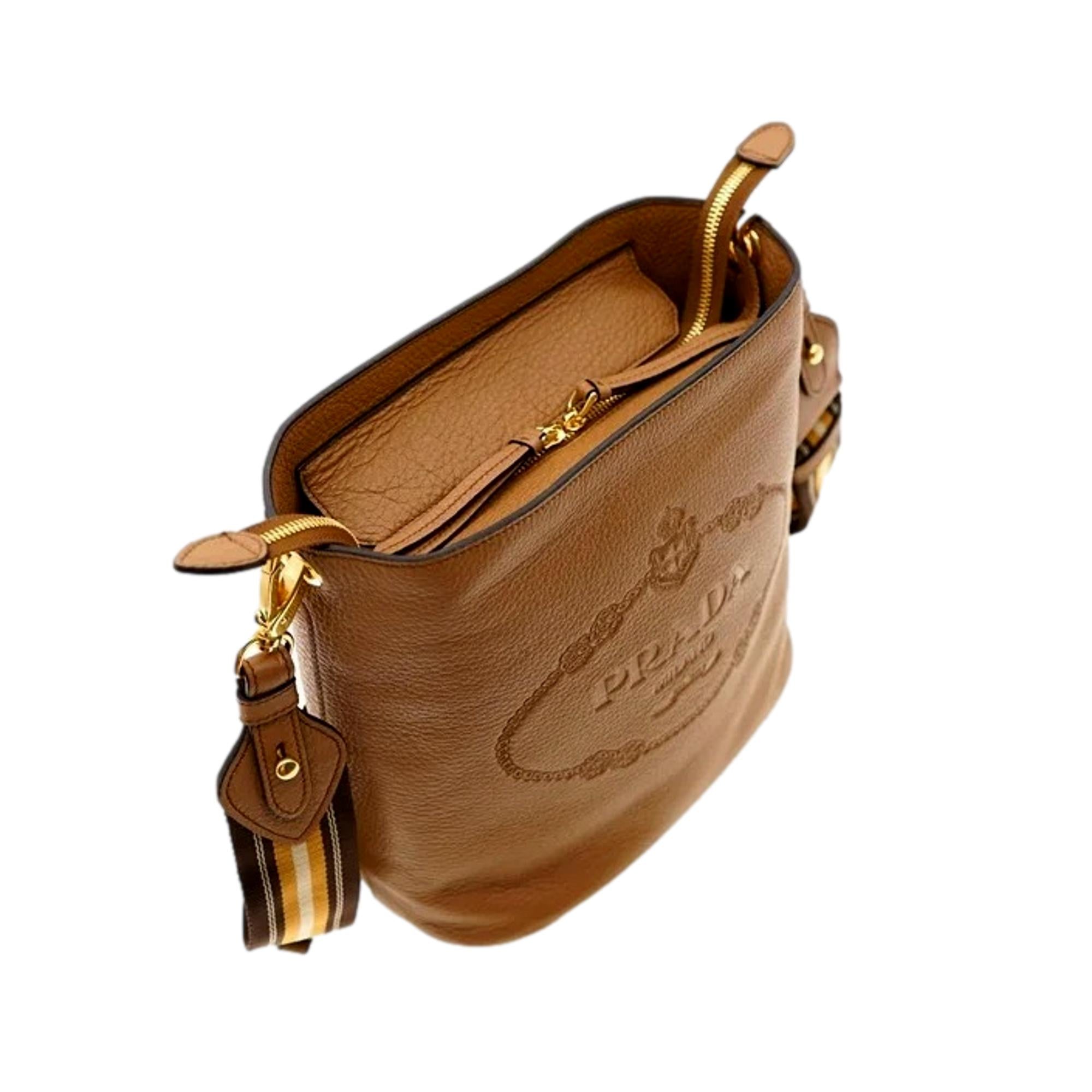 Prada Vitello Phenix Bucket Crossbody Bag Caramel Brown Web Strap available at Queen Bee of Beverly Hills