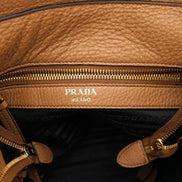 Prada Vitello Phenix Bucket Crossbody Bag Caramel Brown Web Strap available at Queen Bee of Beverly Hills