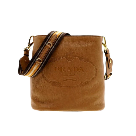 Prada Vitello Phenix Bucket Crossbody Bag Caramel Brown Web Strap available at Queen Bee of Beverly Hills