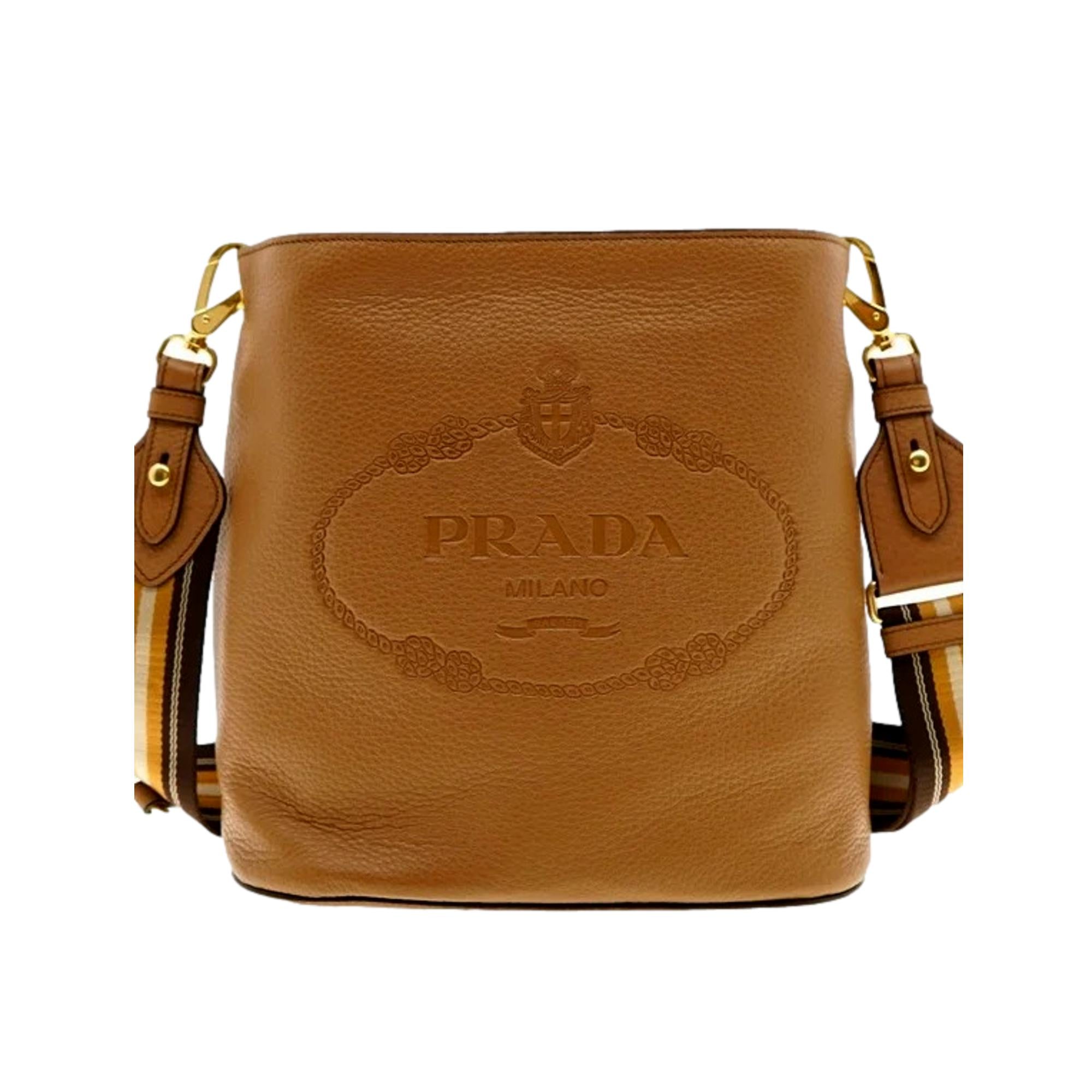 Prada Vitello Phenix Bucket Crossbody Bag Caramel Brown Web Strap available at Queen Bee of Beverly Hills
