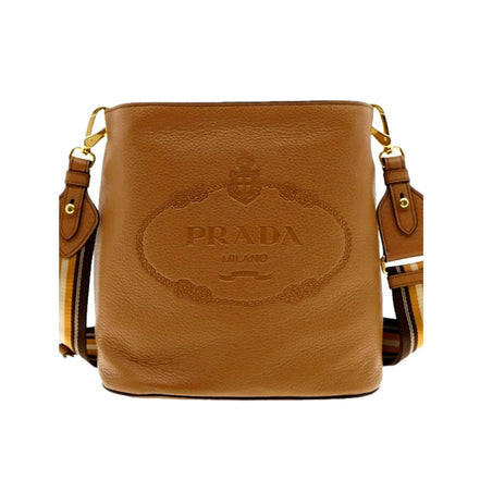 Prada Vitello Phenix Bucket Crossbody Bag Caramel Brown Web Strap available at Queen Bee of Beverly Hills